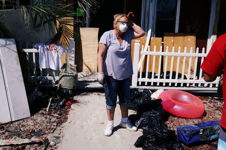 People clean up their house that was destroyed following Hurricane Michael in Mexico Beach, Florida, U.S., October 13, 2018. REUTERS/Carlo Allegri