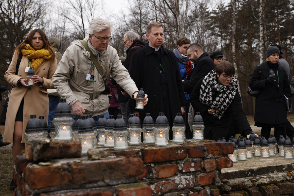 People place candles at the former crematorium as they attend a ceremony in the former Nazi German concentration and extermination camp Auschwitz during ceremonies marking the 78th anniversary of the liberation of the camp in Brzezinka, Poland, Friday, Jan. 27, 2023. (AP Photo/Michal Dyjuk)