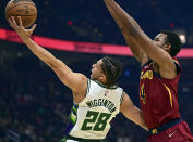 Milwaukee Bucks guard Lindell Wigginton goes to the basket against Cleveland Cavaliers center Evan Mobley in the first half of an NBA basketball game, Sunday, April 10, 2022, in Cleveland. (AP Photo/David Dermer)