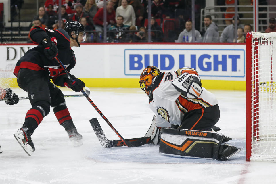 Carolina Hurricanes center Sebastian Aho, left, of Finland, misses a shot on goal against Anaheim Ducks goaltender Ryan Miller (30) during the second period of an NHL hockey game in Raleigh, N.C., Friday, Jan. 17, 2020. (AP Photo/Gerry Broome)