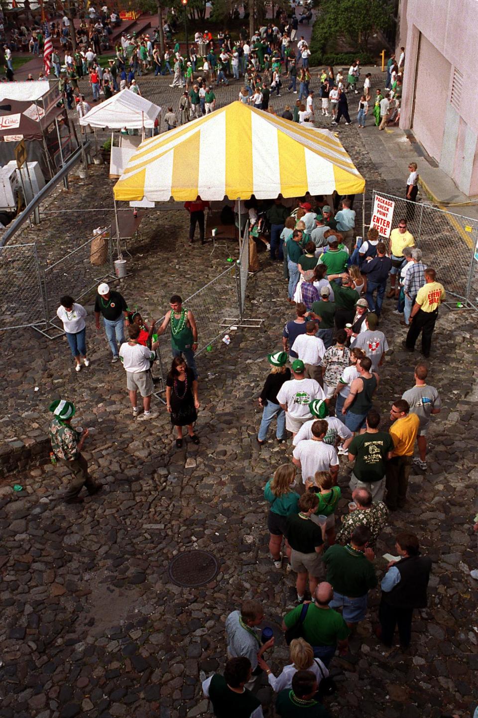 St. Patrick's Day patrons stand in line at one of the gates to continue the celebration on River Street in March 2000 after the parade.