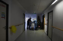 Two Belgian Army medics help a patient to walk who is recovering from COVID-19 at the St. Michiel Hospital in Brussels, Tuesday, Nov. 24, 2020. The Belgian military has been called into several hospitals and care homes to alleviate the stress on healthcare personnel. (AP Photo/Virginia Mayo)