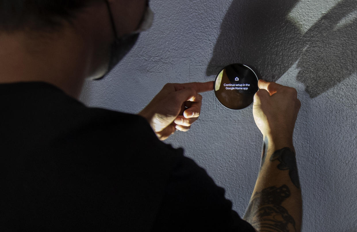 Chase Collier installs a new Nest smart thermostat from OhmConnect. The display says: Continue setup in the Google home app.
