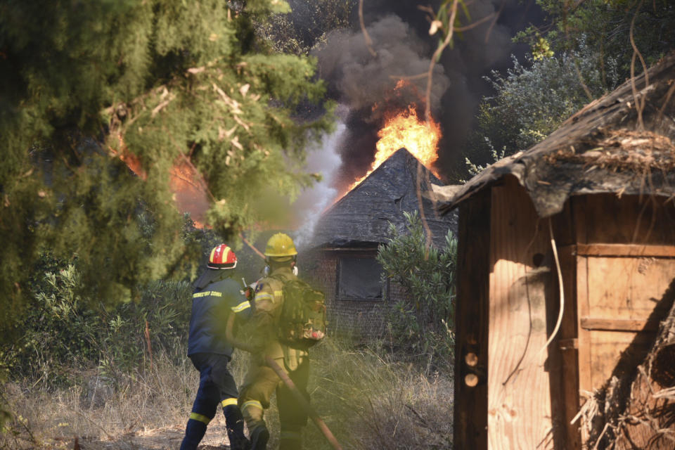 Firefighters operate during a wildfire near Lampiri village, west of Patras, Greece, Saturday, Jul. 31, 2021. The fire, which started high up on a mountain slope, has moved dangerously close to seaside towns and the Fire Service has send a boat to help in a possible evacuation of people. (AP Photo/Andreas Alexopoulos)