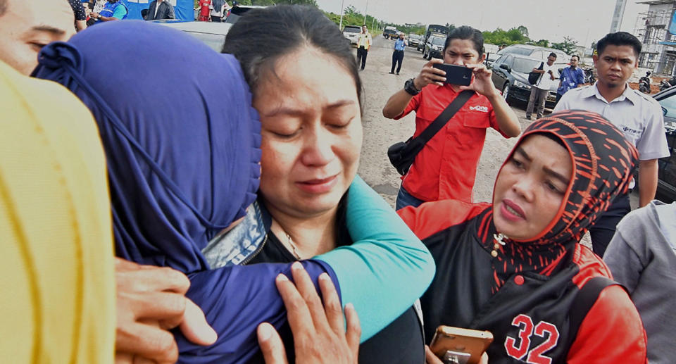 Putri (centre), is consoled over the loss of her husband and child who were passengers on board the ill-fated Lion Air flight JT 610. Source: Getty Images