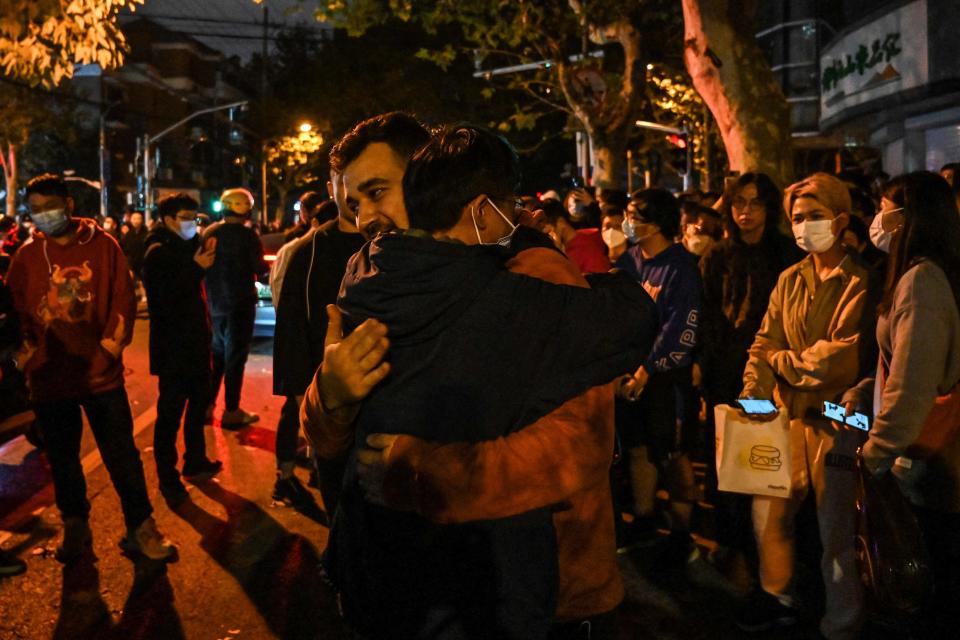 A man hugs another to show support during a demonsration in Shanghai on November 27, 2022, where protests against China's zero-Covid policy took place the night before following a deadly fire in Urumqi, the capital of the Xinjiang region.