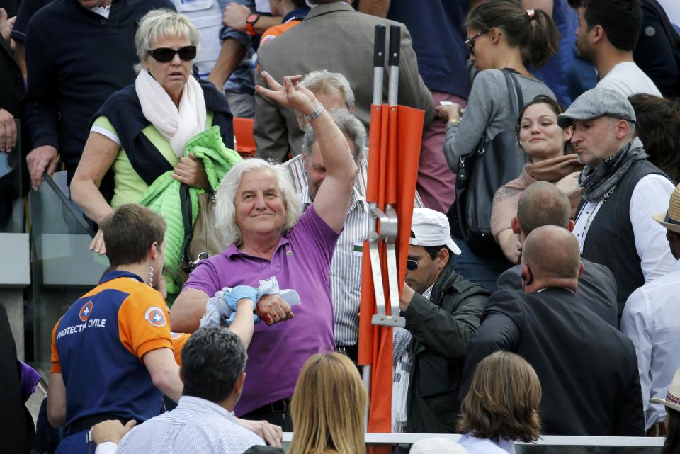 A spectator receives medical assistance after a metal structure collapsed in the tribune on the Philippe Chartier tennis court during the men's quarter-final match between Tsonga and Nishikori during the French Open tennis tournament in Paris