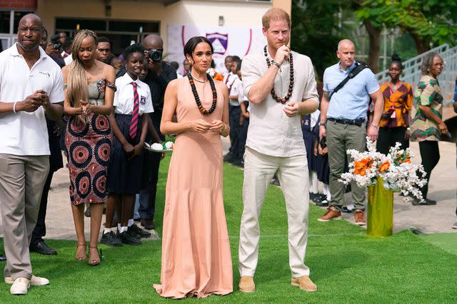 <p>AP Photo/Sunday Alamba</p> Meghan Markle and Prince Harry visit the Lightway Academy in Abuja