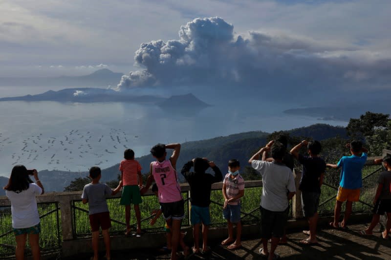 Residents look at the errupting Taal Volcano in Tagaytay City