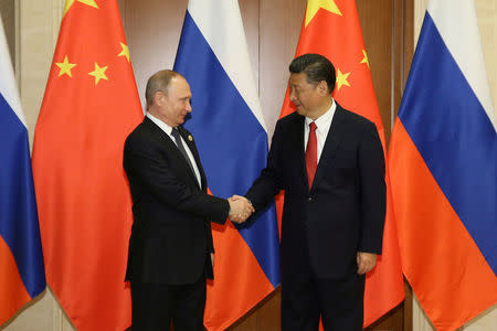 Russian President Vladimir Putin (L) shakes hands with Chinese President Xi Jinping ahead of a bilateral meeting at Diaoyutai State Guesthouse in Beijing, China, 14 May 2017. REUTERS/Wu Hong