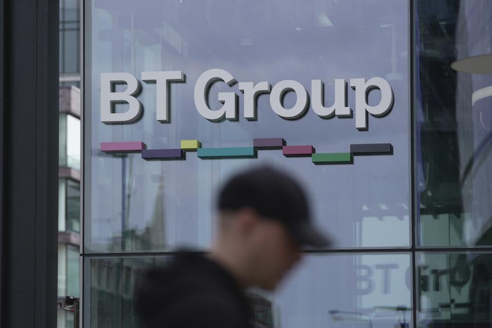 A man walks in front of the BT headquarters, in London, Thursday, May 18, 2023. U.K. telecom company BT Group said Thursday that it plans to shed up to 55,000 jobs by the end of the decade as part of an overhaul aimed at slimming down its workforce to slash costs. (AP Photo/Kin Cheung)
