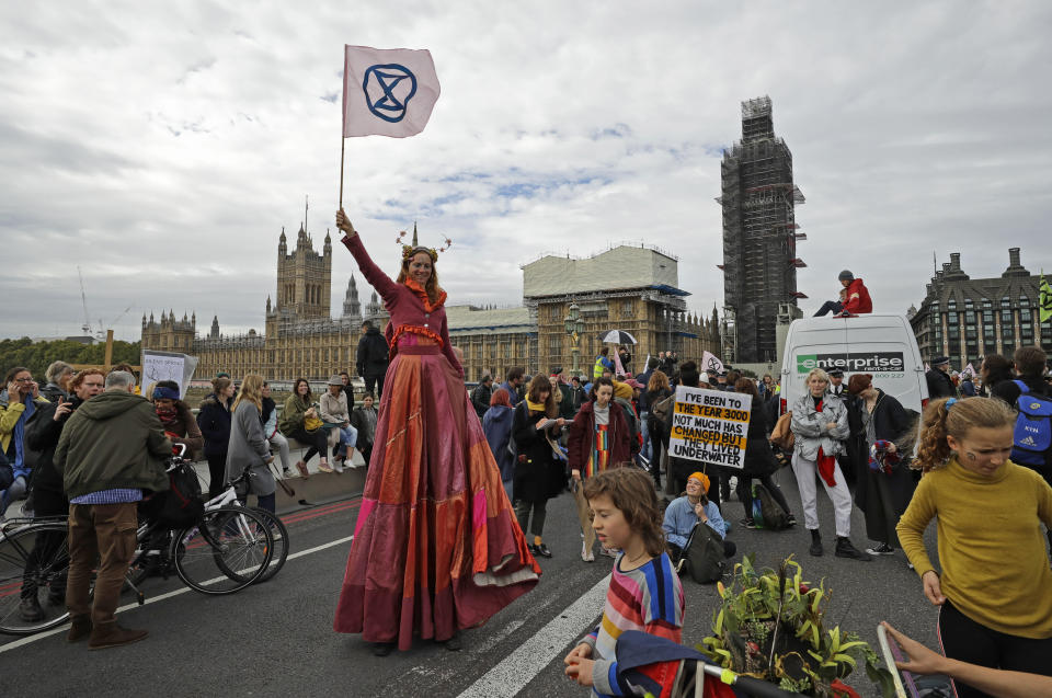 Climate protestors block Westminster Bridge leading to Britain's Parliament, rear, in central London Monday, Oct. 7, 2019, in an attempt to disrupt the heart of government. (AP Photo/Matt Dunham)