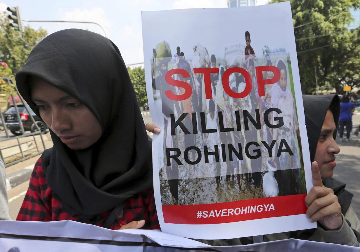Women display a poster during a rally against the persecution of Rohingya Muslims outside the Myanmar embassy in Jakarta, Indonesia. (AP Photo/Tatan Syuflana)