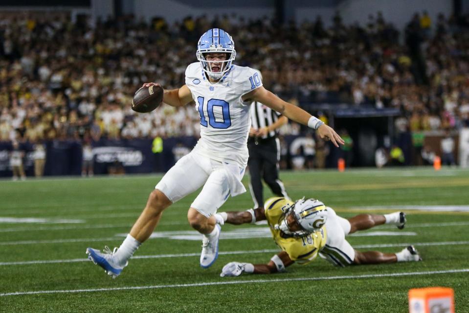 North Carolina Tar Heels quarterback Drake Maye (10) scrambles past Georgia Tech Yellow Jackets defensive back Ahmari Harvey (18) in the first half at Bobby Dodd Stadium at Hyundai Field.