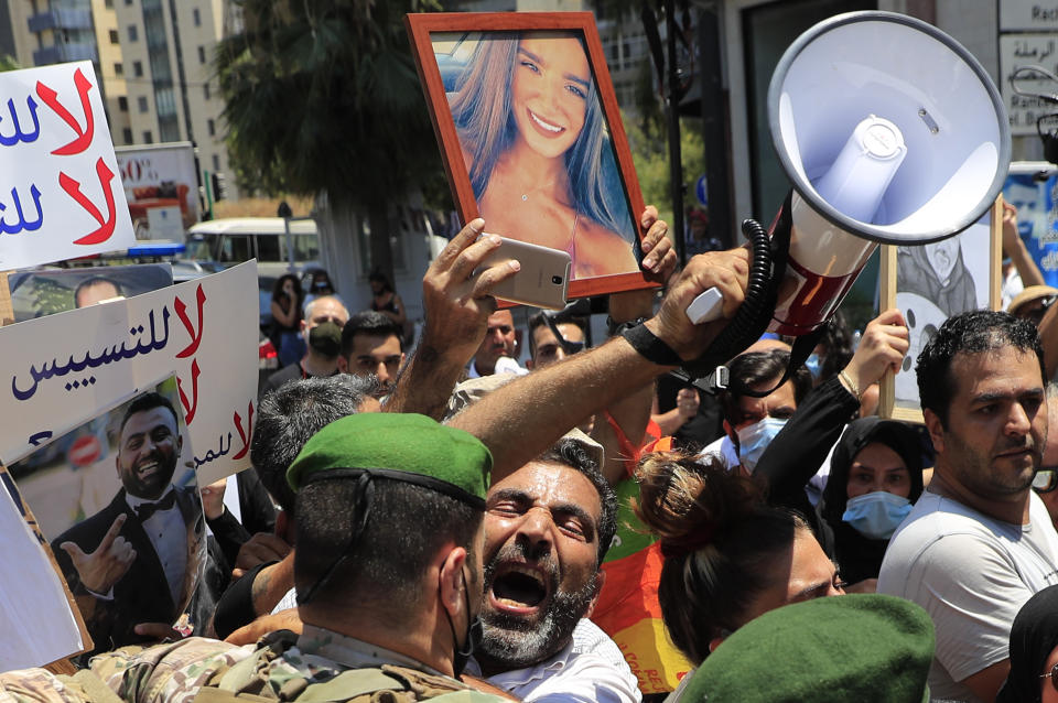 A Lebanese man who lost her son during the last year's massive blast at Beirut's seaport, shout slogans as he pushed back by a Lebanese army soldier after he tries with other to reach the tightly-secured residents of parliament speaker Nabih Berri, in Beirut, Lebanon, Friday, July 9, 2021. The protest came after last week's decision by the judge to pursue senior politicians and former and current security chiefs in the case, and requested permission for their prosecution. (AP Photo/Hussein Malla)