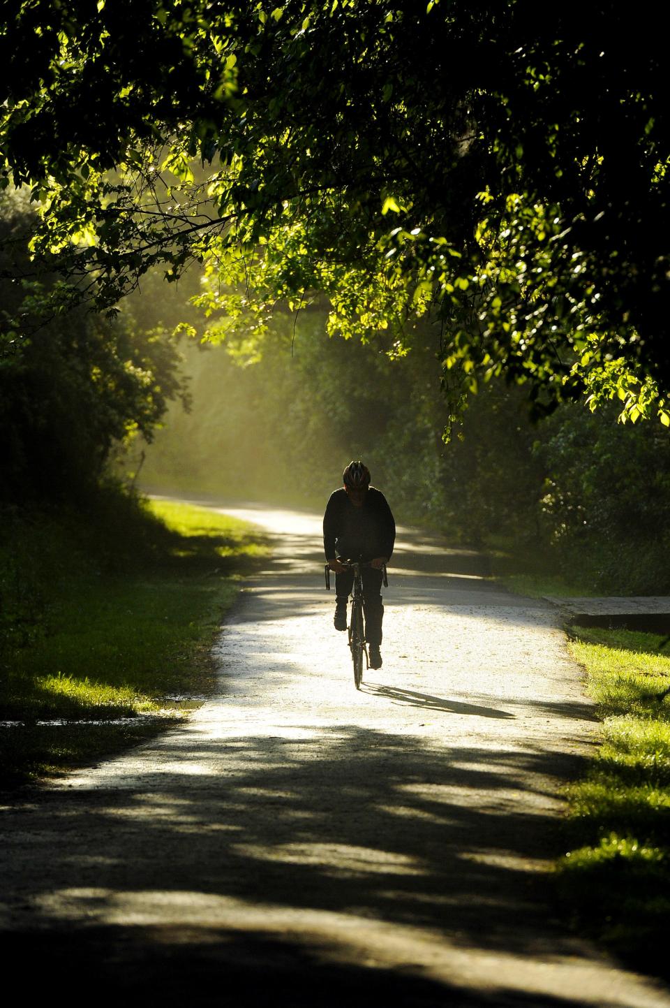 A biker rides early in the morning on the Shelby Bottoms Greenway in Nashville on May 7, 2013.