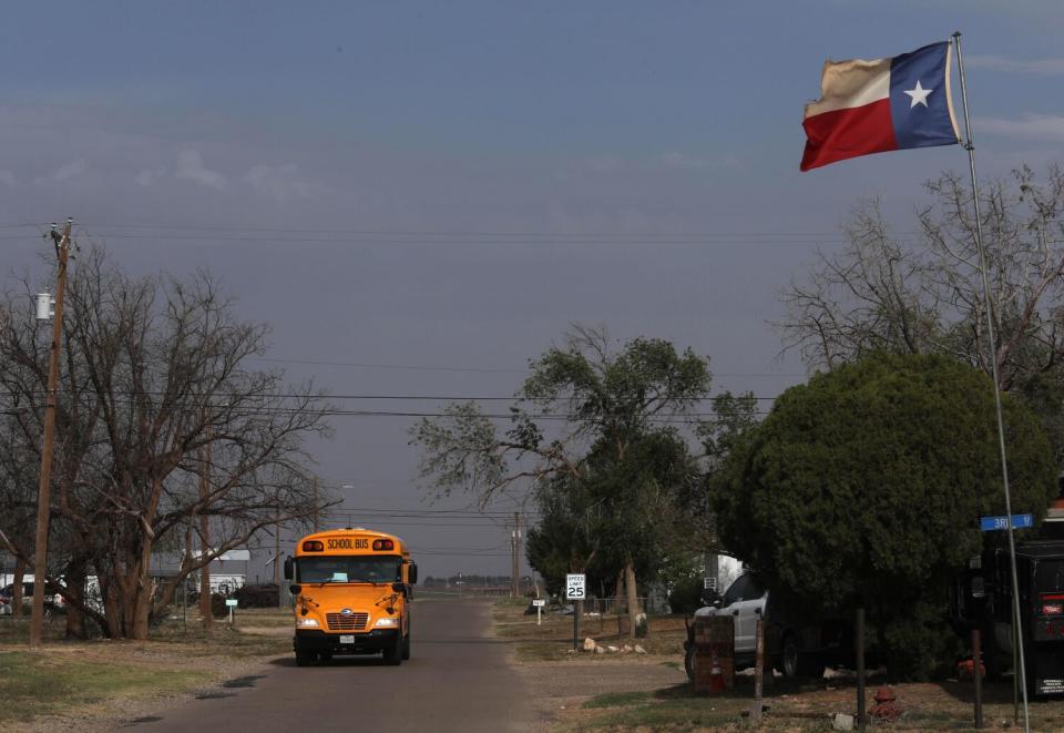 A school bus makes its way through downtown Meadow, Texas.