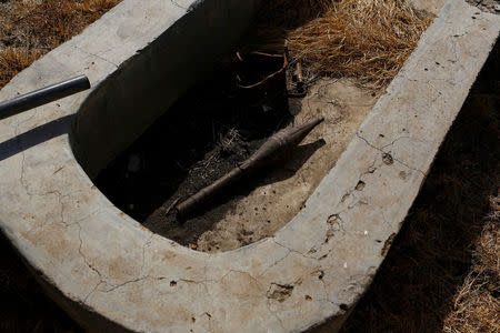 An unexploded rocket propelled grenade lies inside a cement water catchment in the village of Nialdhiu, northern South Sudan, February 7, 2017. REUTERS/Siegfried Modola