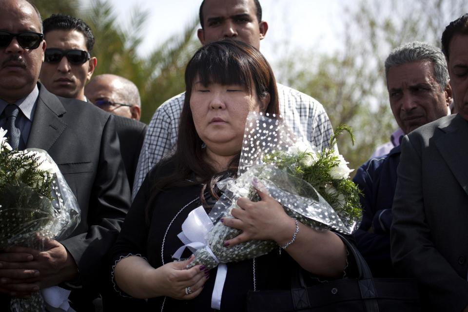 Japanese travel agent Okumura Hatsuko, holds flowers as she pays respect to Japanese tourists that died from a hot air balloon accident, in Luxor, Egypt, Wednesday, Feb. 27, 2013. A hot air balloon carrying tourists over Egypt's ancient city of Luxor caught fire on Tuesday, Feb. 26, 2013 and some passengers trying to escape the flames leaped to their deaths before the craft crashed in a sugar cane field. At least 19 tourists were killed in one of the world's deadliest ballooning accidents. (AP Photo/Nasser Nasser)