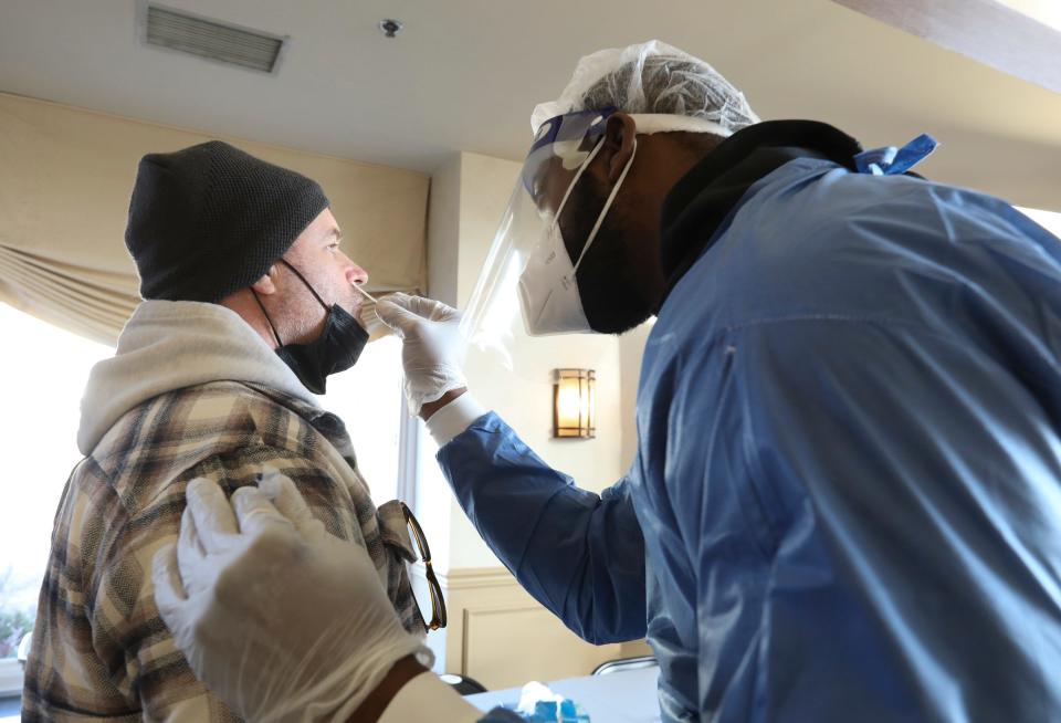 Robert Akey of Sloatsburg receives a COVID-19 antigen test from Dexton Cummins at Patriot Hills Golf Course in Stony Point on Tuesday, January 4, 2022.