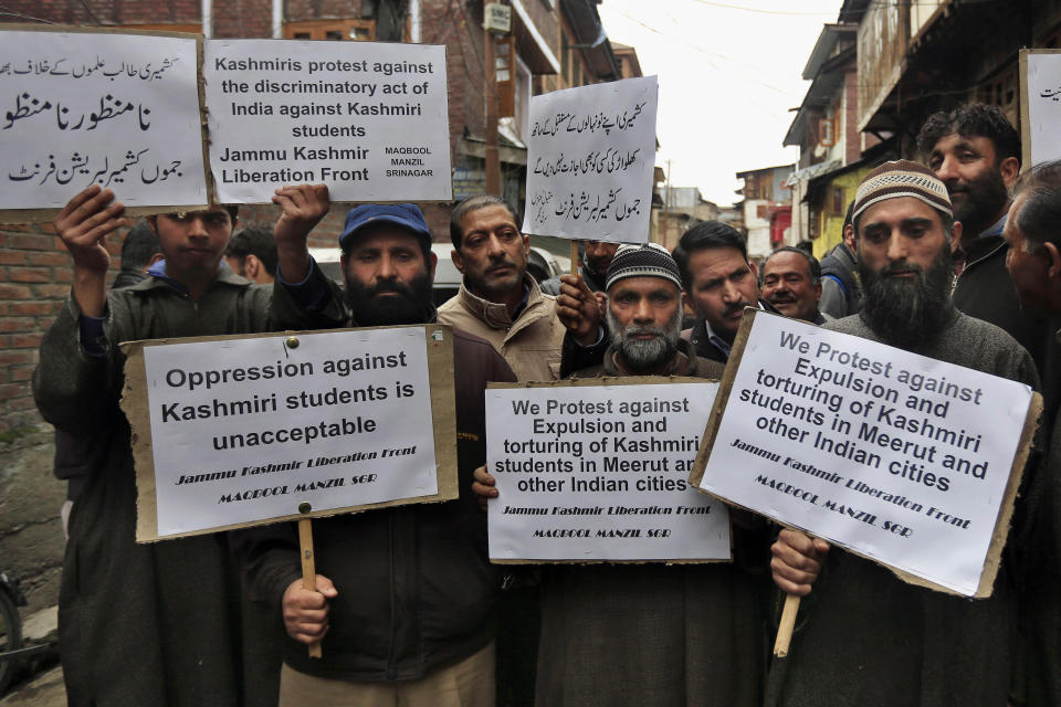 Supporters of Jammu Kashmir Liberation Front (JKLF) chairman Yasin Malik hold placards during a protest in Srinagar, India, Friday, March 7, 2014. Dozens of Muslim students from the disputed Indian territory of Kashmir were expelled from their university and briefly threatened with sedition charges because they cheered for the Pakistani cricket team during a televised match against archrival India, police said Thursday, while the Indian state's elected leader called for leniency. (AP Photo/Dar Yasin)