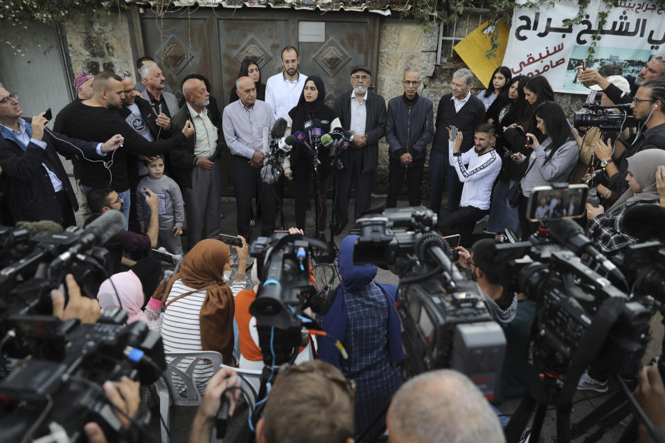 Palestinian activist Muna al-Kurd, center, stands with her neighbors at a press conference in the Sheikh Jarrah neighborhood of east Jerusalem, Tuesday, Nov. 2, 2021. Palestinian families in the tense neighborhood of Jerusalem have rejected an offer that would have delayed their eviction by Jewish settlers. In a statement on Tuesday, the four families said their decision springs from "our belief in the justice of our cause and our right to our homes and our homeland." (AP Photo/Mahmoud Illean)