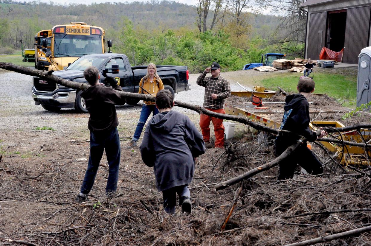 Edgewood Middle School seventh graders are busy removing tree limbs that fell on top of a trailer in last year's wind storm. They helped clean up debris in the Killbuck marsh as part of a science project.