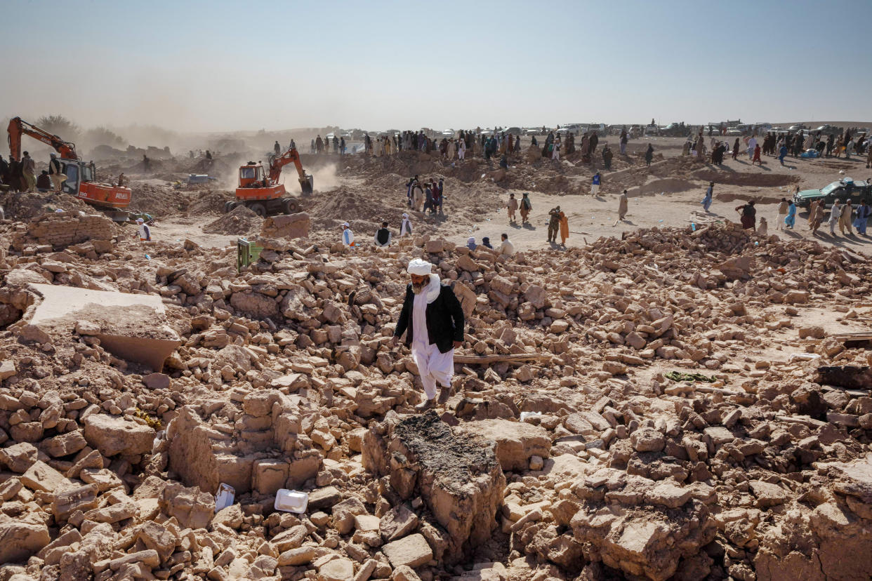 People walk through rubble after an earthquake.