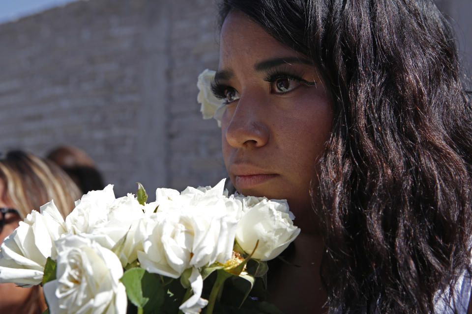 An activist from the "Women from the Periphery for the Periphery Collective" holds flowers where the body of 2-year-old Samantha was found dead outside her home in June, during a caravan to protest femicide in Ecatepec, Mexico, Sunday, Oct. 6, 2019. The collective of activists and the relatives of murdered females visited four sites where females were found dead in Ecatepec, in the state of Mexico where authorities declared in 2015 an alert concerning gender violence against women. (AP Photo/Ginnette Riquelme)