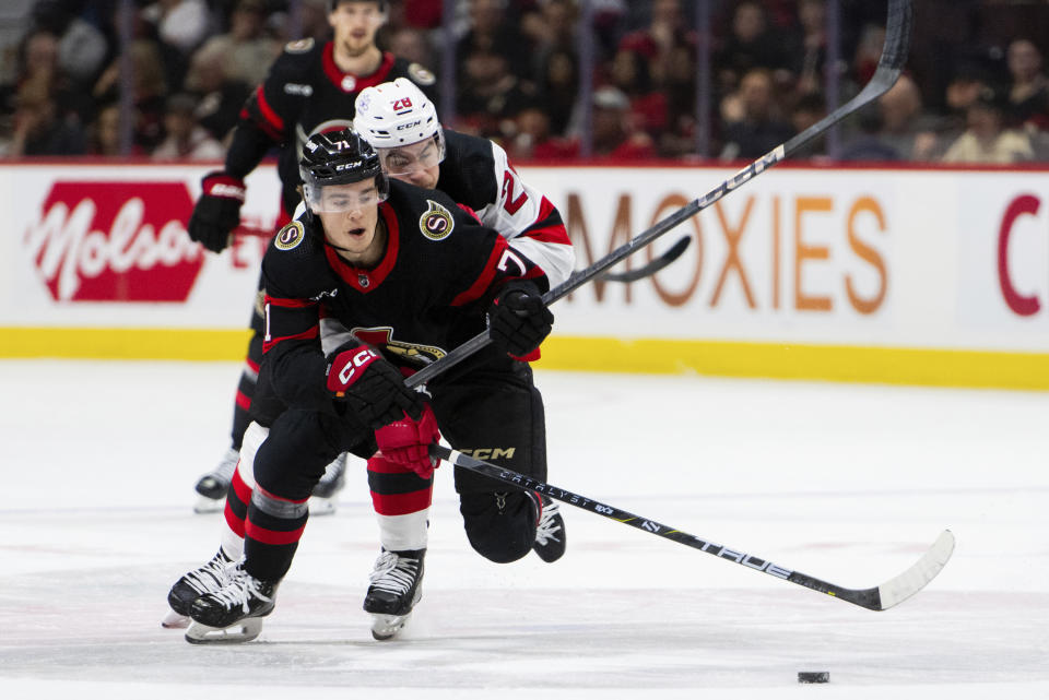 New Jersey Devils right wing Timo Meier (28) and Ottawa Senators centre Ridly Greig (71) vie for control of the puck during first-period NHL hockey game action in Ottawa, Ontario, Saturday, April 6, 2024. (Spencer Colby/The Canadian Press via AP)