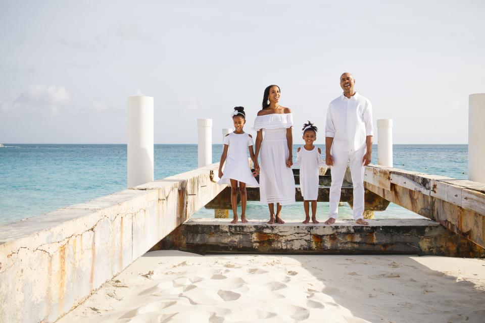 The author and her family wearing all white standing on a beach in Turks and Caicos.