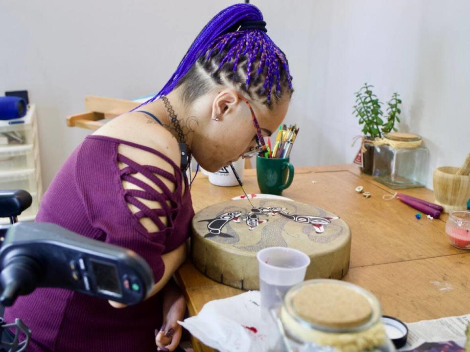 Jenna Wuthrich has limited mobility in her arms, so she's learned to use her mouth to do most things — including paint. (Nadia Mansour/CBC - image credit)