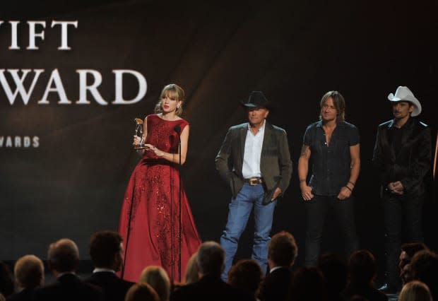 <p> Taylor Swift accepts the Pinnacle Award from presenters <strong><a href="https://parade.com/news/george-strait-gives-military-family-life-changing-gift-holidays" rel="nofollow noopener" target="_blank" data-ylk="slk:George Strait;elm:context_link;itc:0;sec:content-canvas" class="link ">George Strait</a></strong>, <strong><a href="https://parade.com/tag/keith-urban" rel="nofollow noopener" target="_blank" data-ylk="slk:Keith Urban;elm:context_link;itc:0;sec:content-canvas" class="link ">Keith Urban</a></strong> and <strong><a href="https://parade.com/tag/brad-paisley/" rel="nofollow noopener" target="_blank" data-ylk="slk:Brad Paisley;elm:context_link;itc:0;sec:content-canvas" class="link ">Brad Paisley</a> </strong>at the CMA Awards on Nov. 6, 2013.</p><p>Frederick Breedon IV/FilmMagic</p>