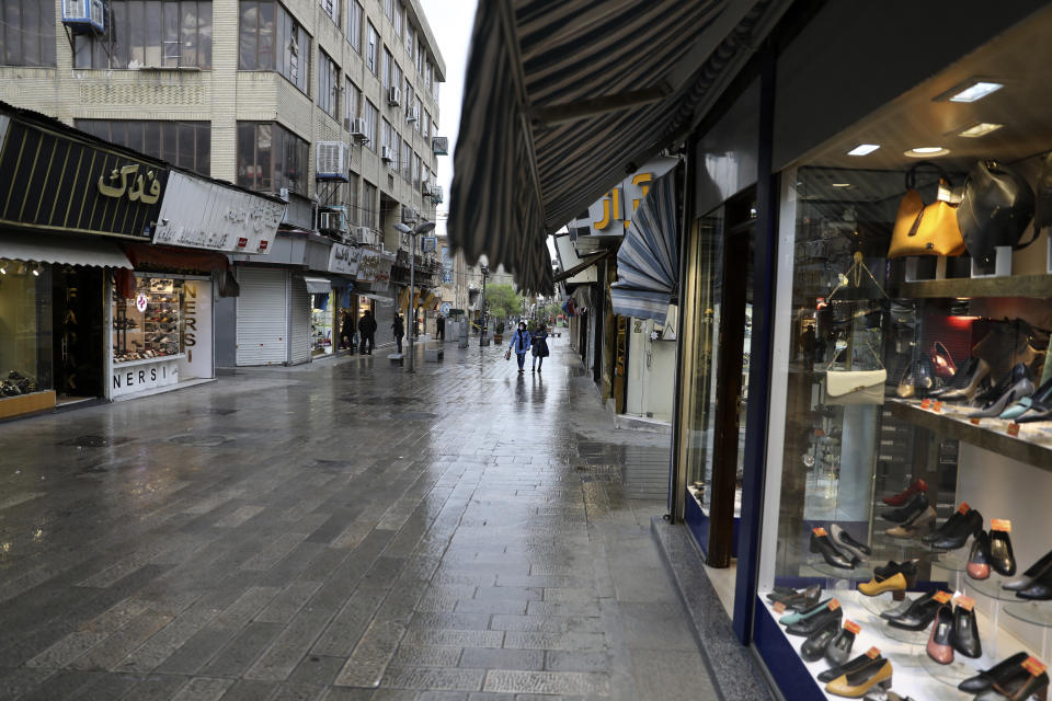 A mostly empty street is seen in a commercial district in downtown Tehran, Iran, Sunday, March 22, 2020. On Sunday, Iran imposed a two-week closure on major shopping malls and centers across the country to prevent spreading the new coronavirus. Pharmacies, supermarkets, groceries and bakeries will remain open. (AP Photo/Vahid Salemi)