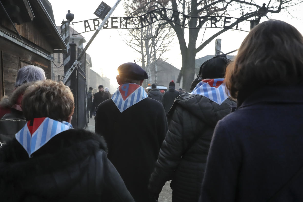 Survivors and their relatives walk through the gates of the Auschwitz Nazi concentration camp to attend the 75th anniversary of its liberation in Oswiecim, Poland, Monday, Jan. 27, 2020. (AP Photo/Czarek Sokolowski)