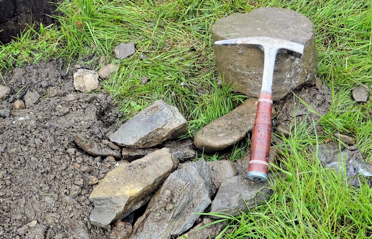 Hammer for a geologist, drill cuttings and a drill core besides the borehole