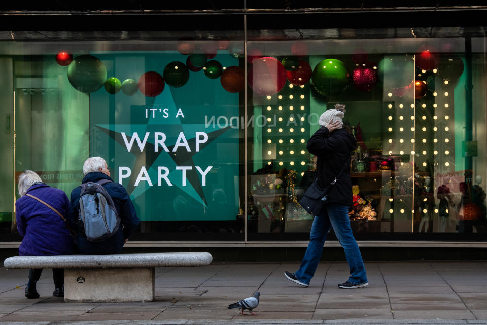 LONDON, ENGLAND - NOVEMBER 07: A shopper walks past a Christmas window display at John Lewis, Oxford Street on November 7, 2021 in London, England. British Health Secretary Sajid Javid urged eligible Britons to get their Covid-19 vaccine boosters - or, if unvaccinated, their first or second jabs - and 