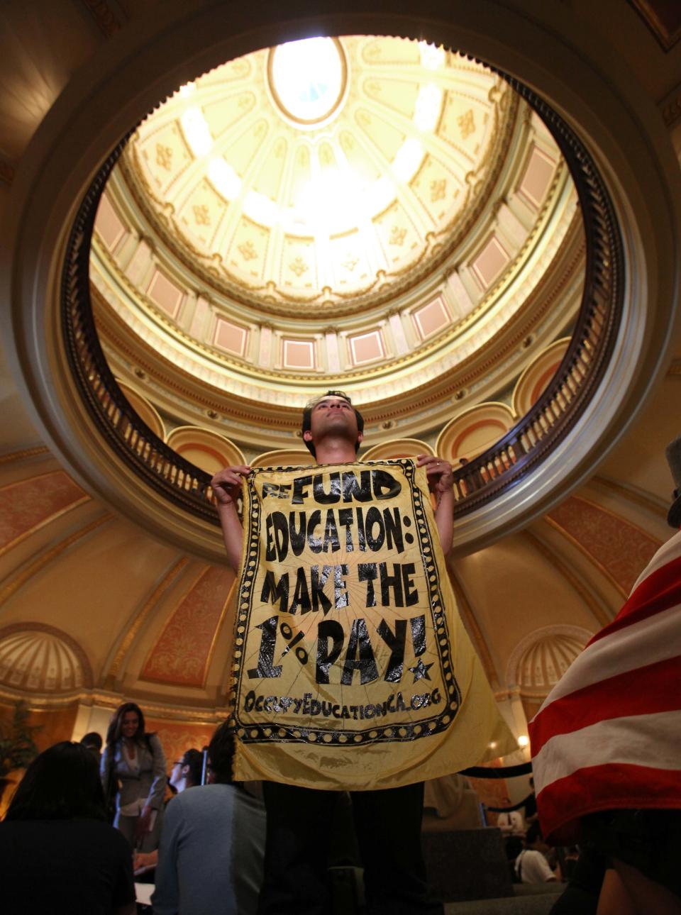 Mark Weirick, an alumni from California State University, Monterey Bay, joined with dozens of others at a sit-in against cuts to higher education held in the rotunda of the Capitol in Sacramento, Calif., Monday, March, 5, 2012. Thousands of college students, teachers and supporters marched to the Capitol as part of a day long protest over state budget cuts to education. The day was capped off with dozens of protesters were arrested after repeated warnings to leave the Capitol after it closed.(AP Photo/Rich Pedroncelli)