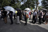 Visitors queue to enter Yasukuni Shrine Saturday, Aug. 15, 2020, in Tokyo. Japan marked the 75th anniversary of the end of World War II. (AP Photo/Eugene Hoshiko)