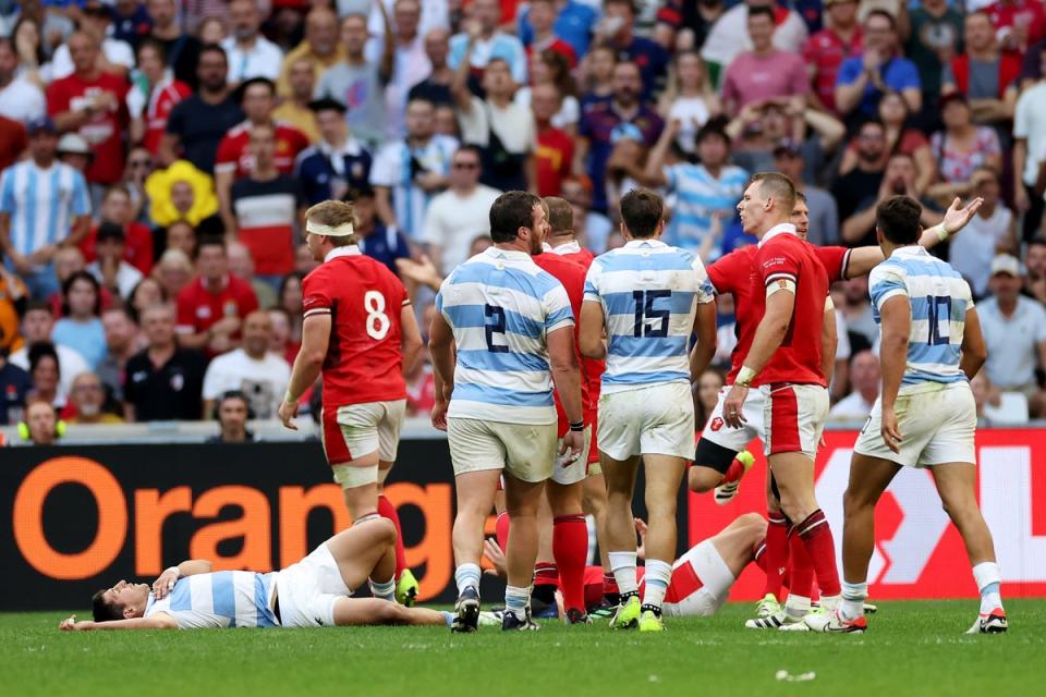 Tomas Cubelli of Argentina lies on the floor after being shoulder-charged off the ball by Josh Adams of Wales (Getty)