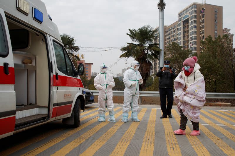 Hospital staff in protective garments pick up a leukaemia patient who arrived from the Hubei province exclusion zone at a checkpoint at the Jiujiang Yangtze River Bridge in Jiujiang