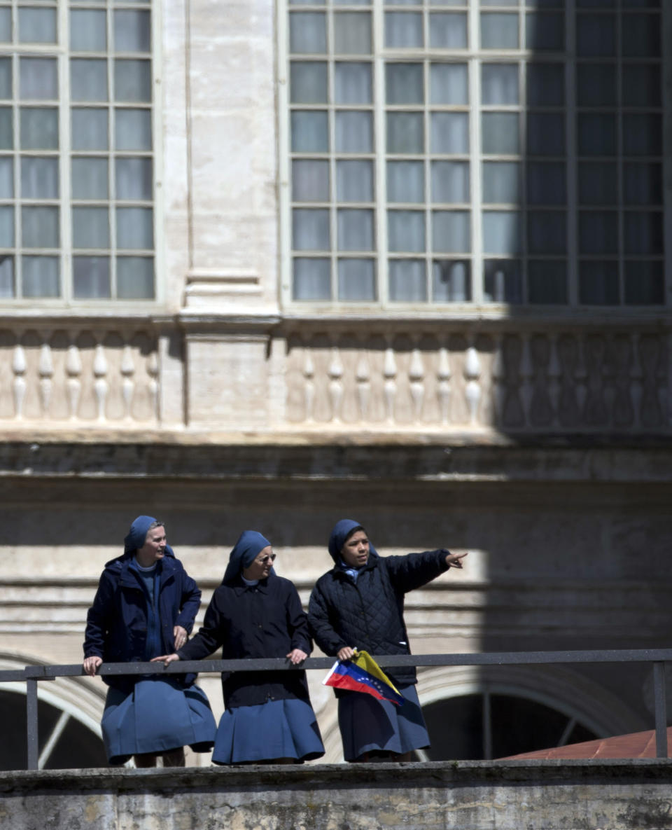 Nuns stand on a rooftop as they look at Pope Francis being driven through the crowd at the end of an Easter Mass in St. Peter's Square at the Vatican, Sunday, April 20, 2014. Celebrating Easter Sunday, Christianity's most joyous and hopeful day, Pope Francis prayed for peace in Ukraine and Syria and for an end to the terrorist attacks in Nigeria that have targeted many Christians. (AP Photo/Alessandra Tarantino)