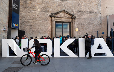 FILE PHOTO: A cyclist rides past a Nokia logo during the Mobile World Congress in Barcelona, Spain February 25, 2018. REUTERS/Yves Herman