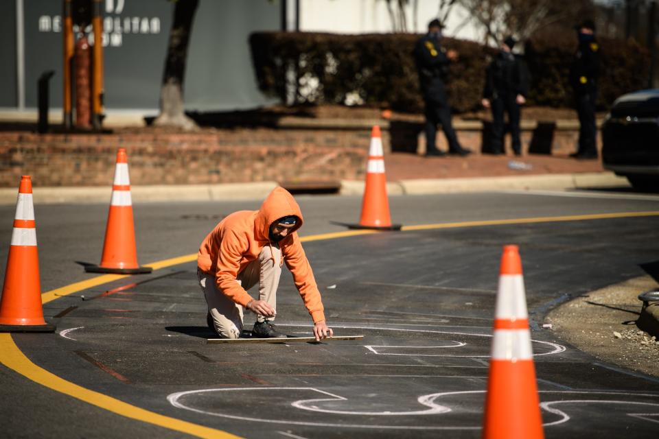 Artist Collyn Strother works on repainting the mural, which was recently removed, around the Market House on Wednesday, Feb. 3, 2021.