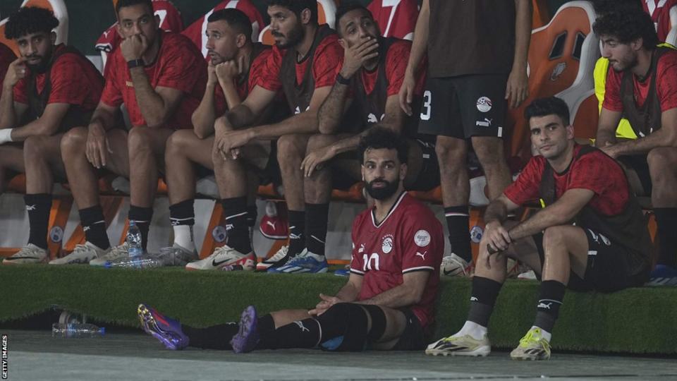 محمد صلاح يجلس خارج المخبأ المصري بعد طرده خلال المباراة ضد غانا.