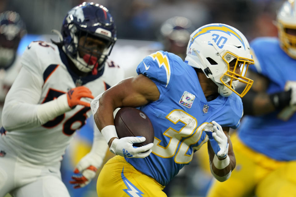 Los Angeles Chargers running back Austin Ekeler (30) runs as Denver Broncos linebacker Baron Browning (56) pursues during the first half of an NFL football game, Monday, Oct. 17, 2022, in Inglewood, Calif. (AP Photo/Marcio Jose Sanchez)