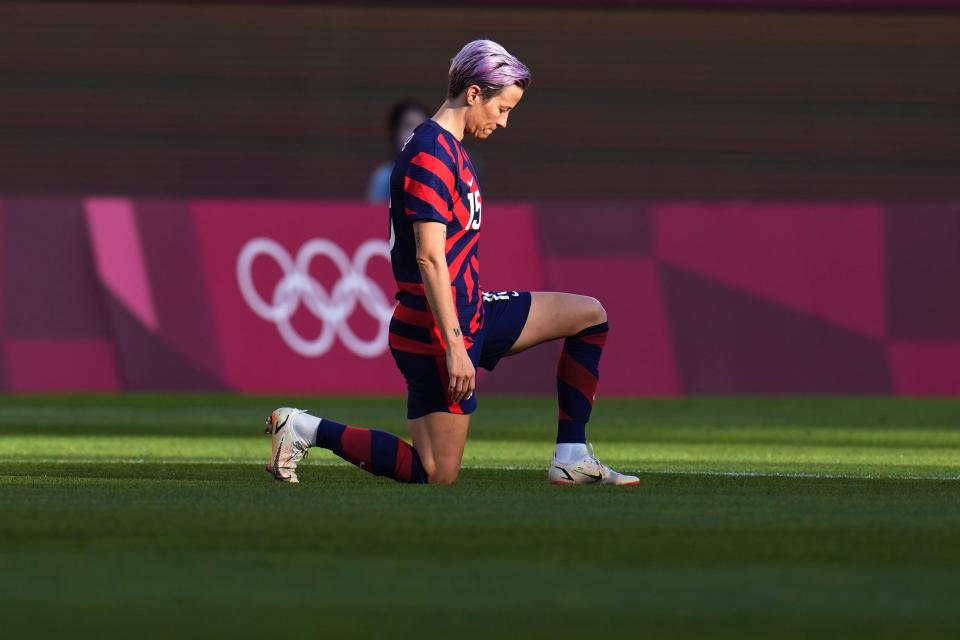 Megan Rapinoe kneels before kickoff.