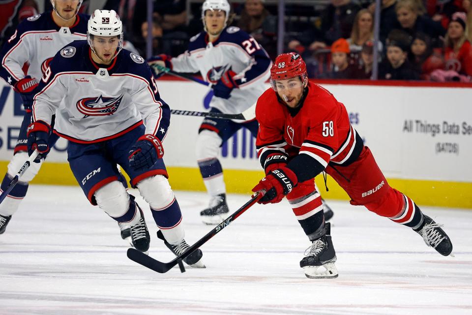 Carolina Hurricanes' Michael Bunting (58) controls the puck in front of Columbus Blue Jackets' Yegor Chinakhov (59) during the first period of an NHL hockey game in Raleigh, N.C., Sunday, Nov. 26, 2023. (AP Photo/Karl B DeBlaker)
