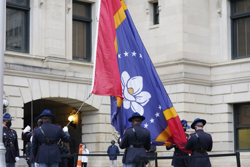 Members of the Mississippi Highway Safety Patrol Honor Guard prepare to raise the new Mississippi State flag at the Capitol in Jackson, Monday, Jan. 11, 2021. Earlier in the afternoon, Republican Gov. Tate Reeves signed a law that created the new state flag with magnolia at the center, six months after the state retired the last state flag in the U.S. that included the Confederate battle emblem. (AP Photo/Rogelio V. Solis)