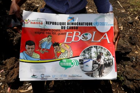 Congolese volunteer Ferdinand Tangenyi displays a flip book he uses to inform people about the Ebola virus, in Goma